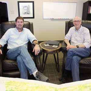 two consultants advisors dallas texas sitting in sofa chairs smiling case bogart